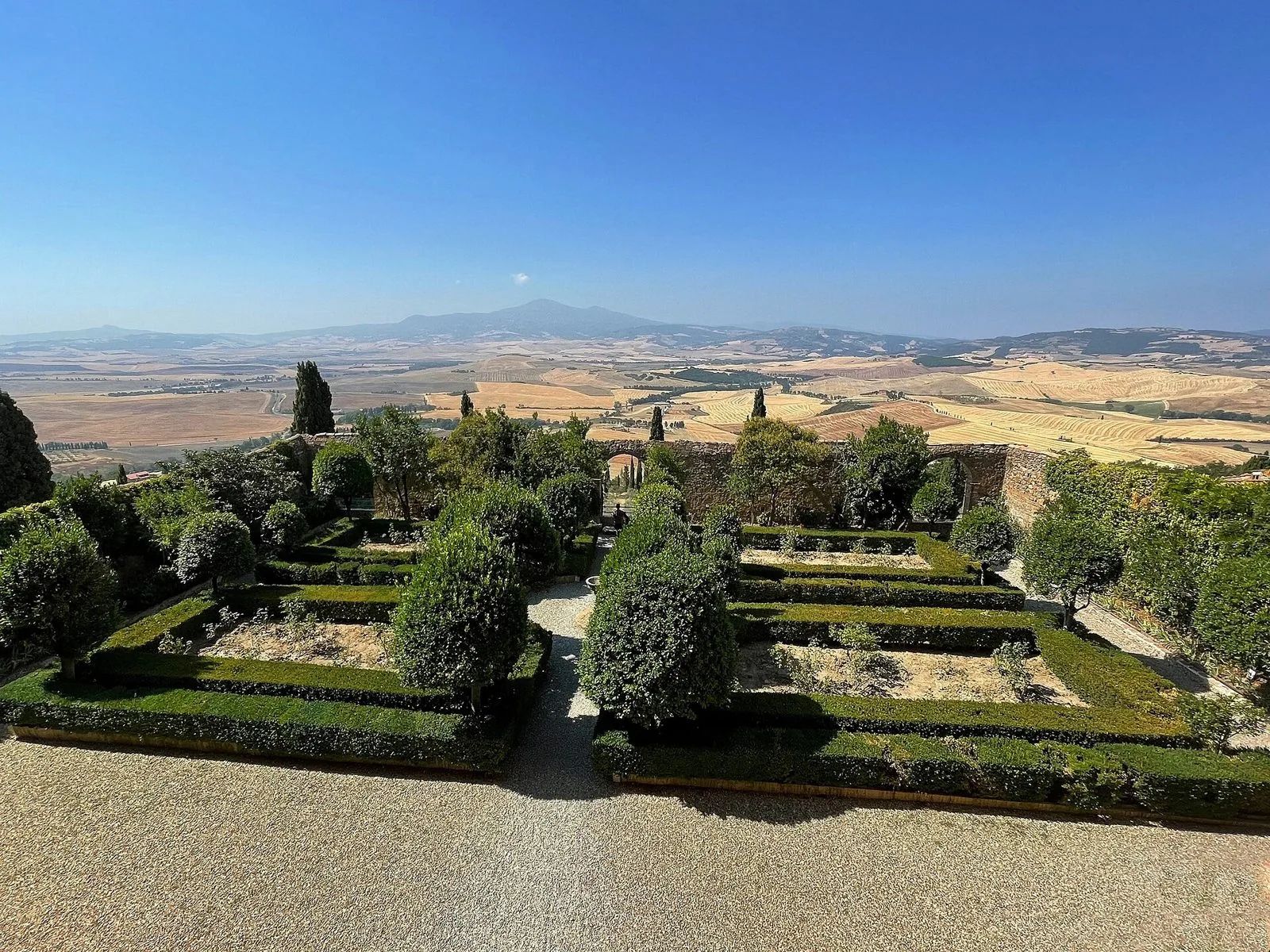 Il giardino pensile di Palazzo Piccolomini a Pienza con siepi geometriche e vista sulla Val d'Orcia e il Monte Amiata